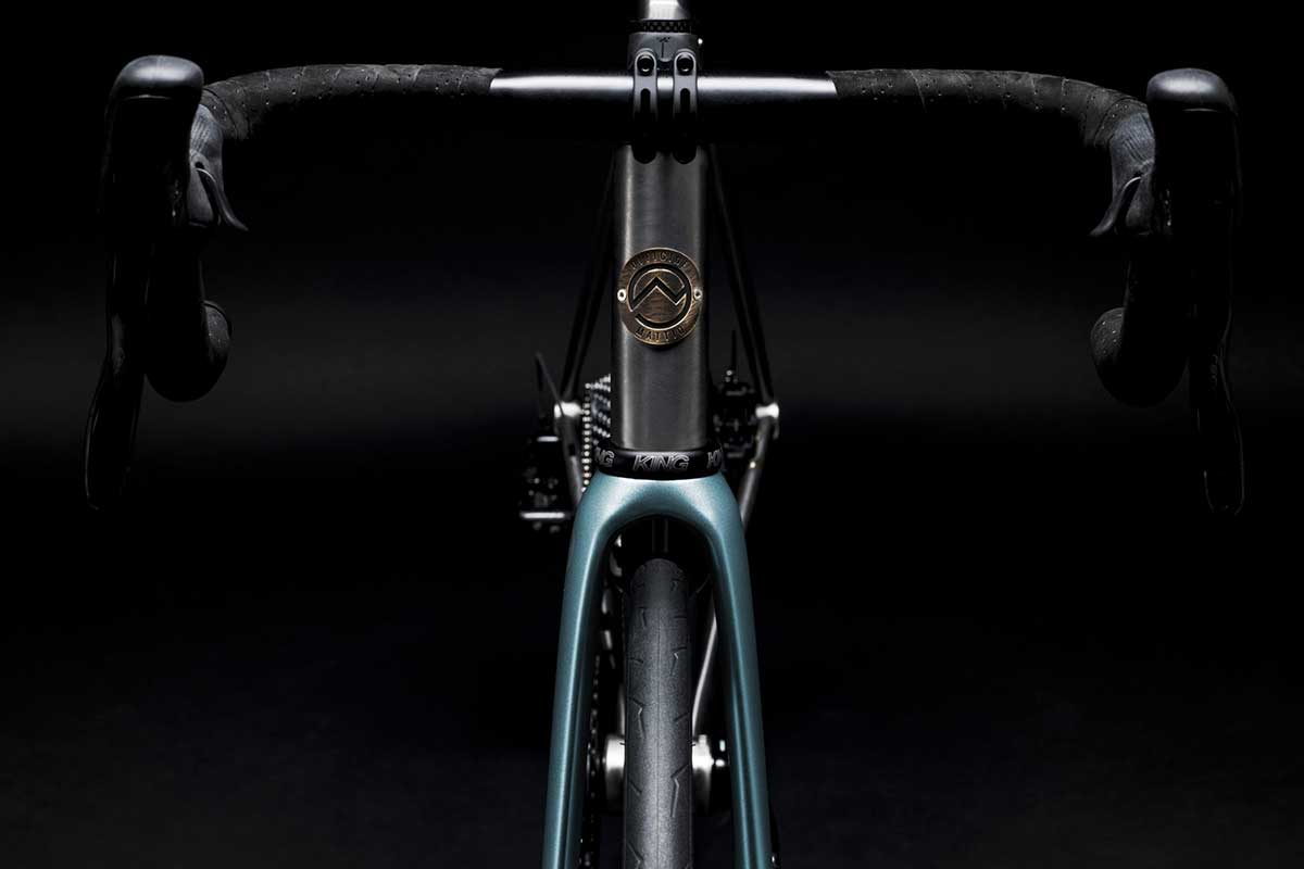 Bicicletta Officine Mattio modello EREMO DISC, telaio in acciaio inossidabile e freni innovativi, fotografia dettaglio manubrio e logo OM